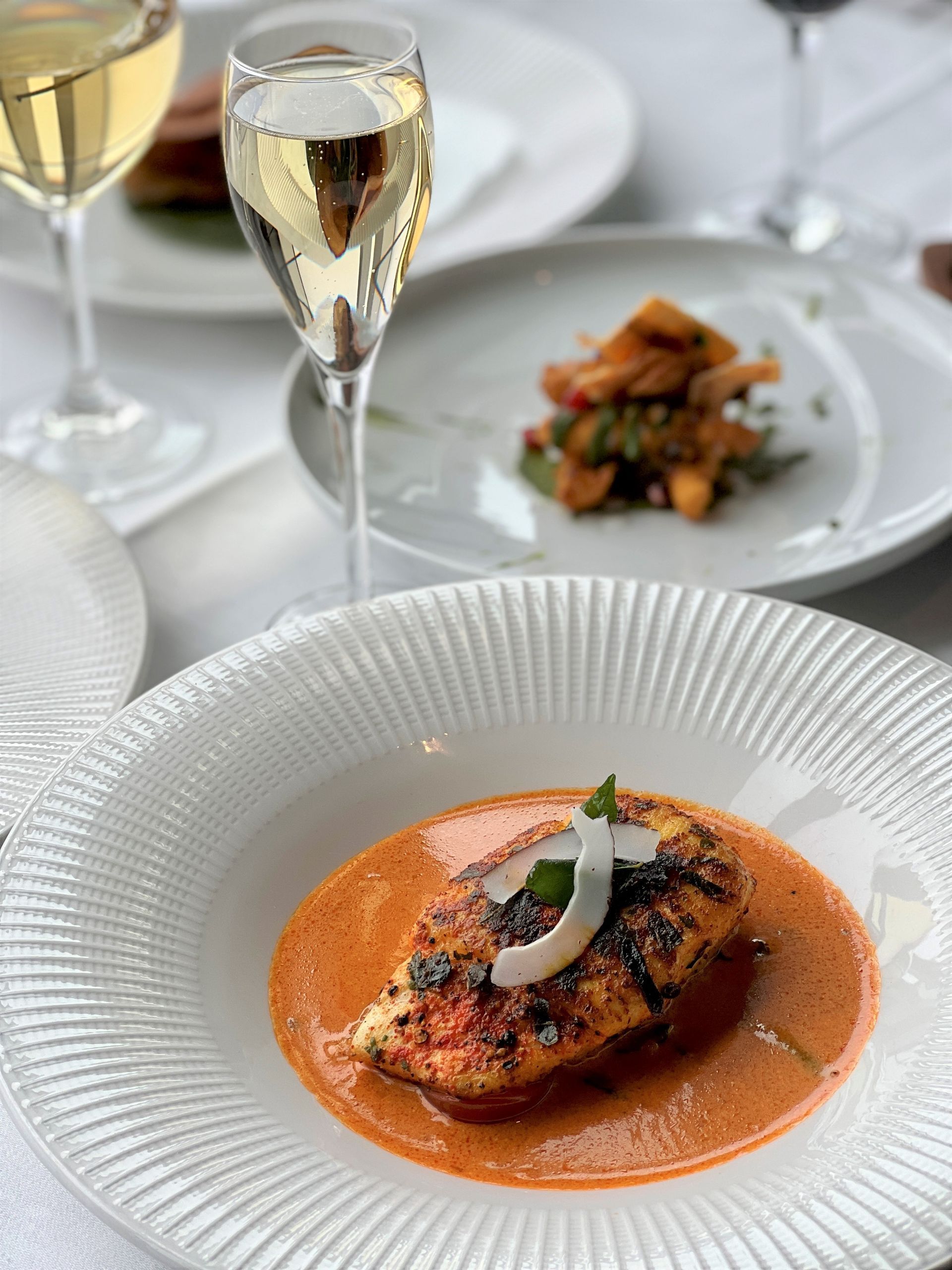 A plate of food and a glass of wine on a table.