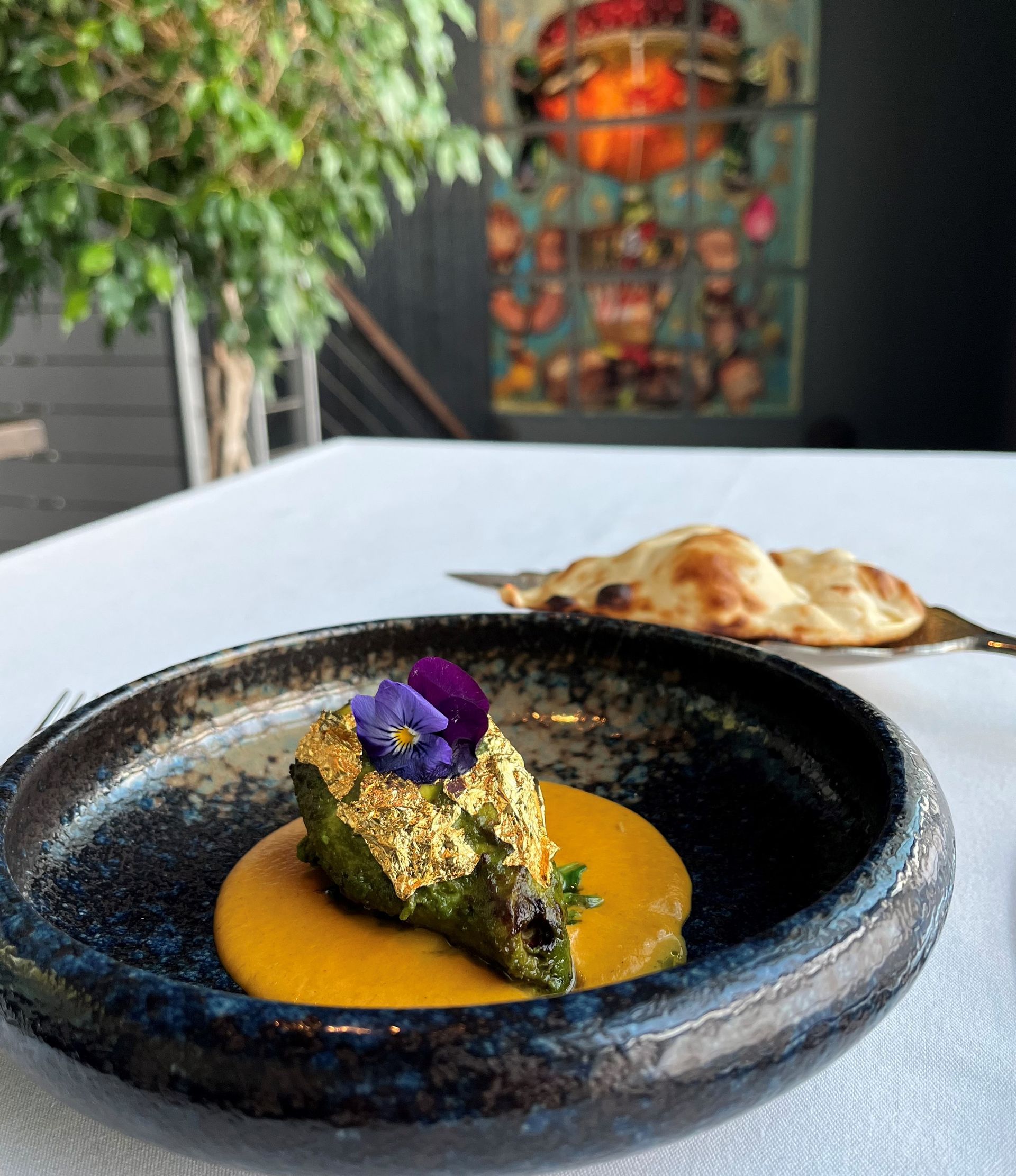 A plate of food with a flower on top of it on a table.