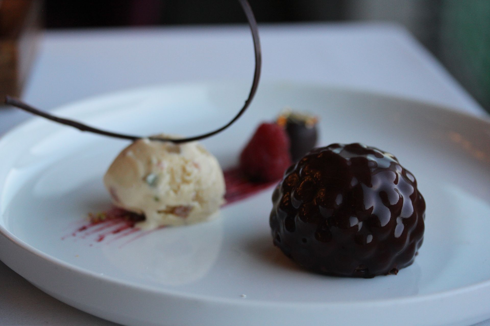 A white plate topped with a chocolate dessert and ice cream