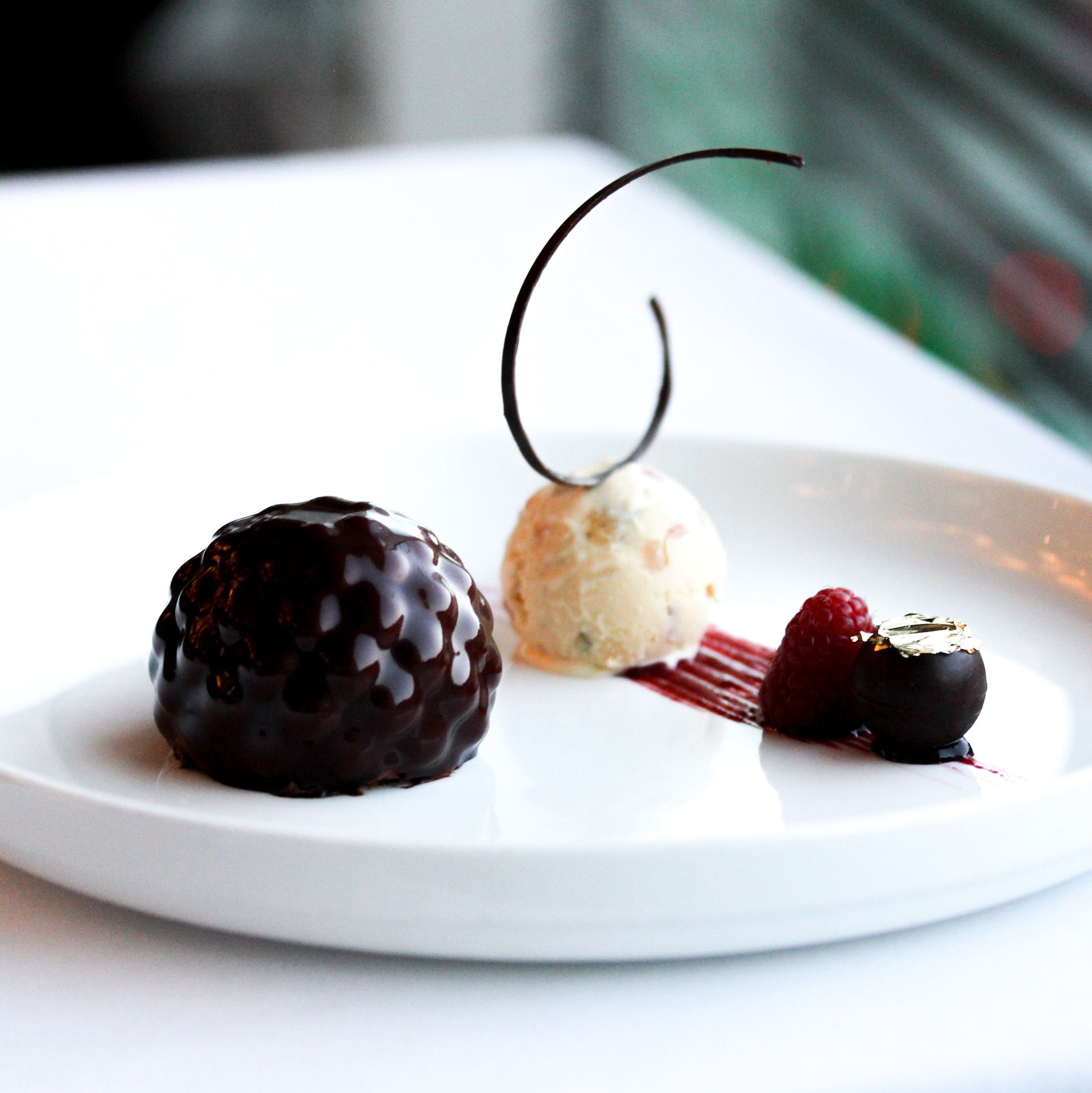 A white plate topped with a chocolate dessert and ice cream