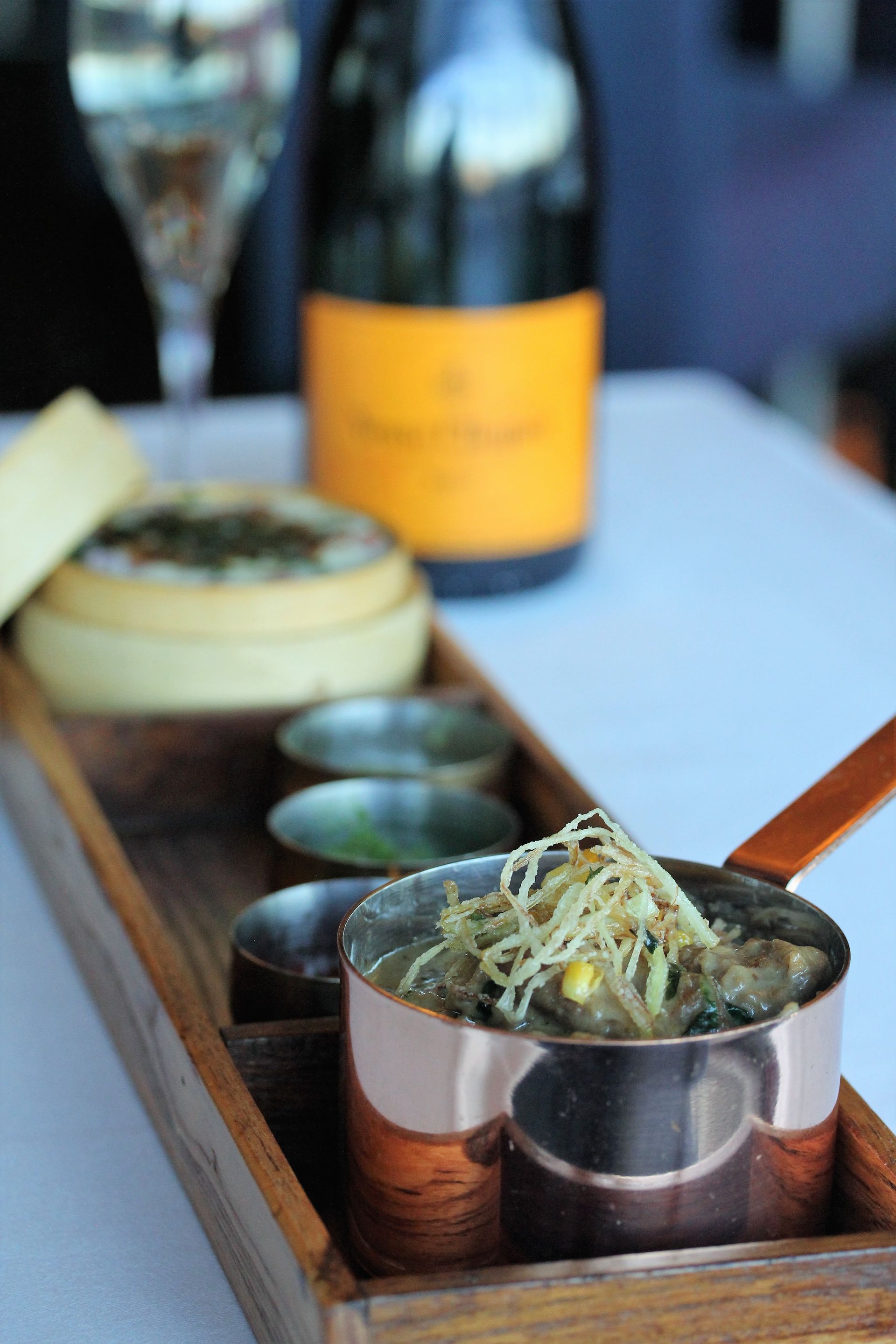 A tray of food with a bottle of champagne in the background