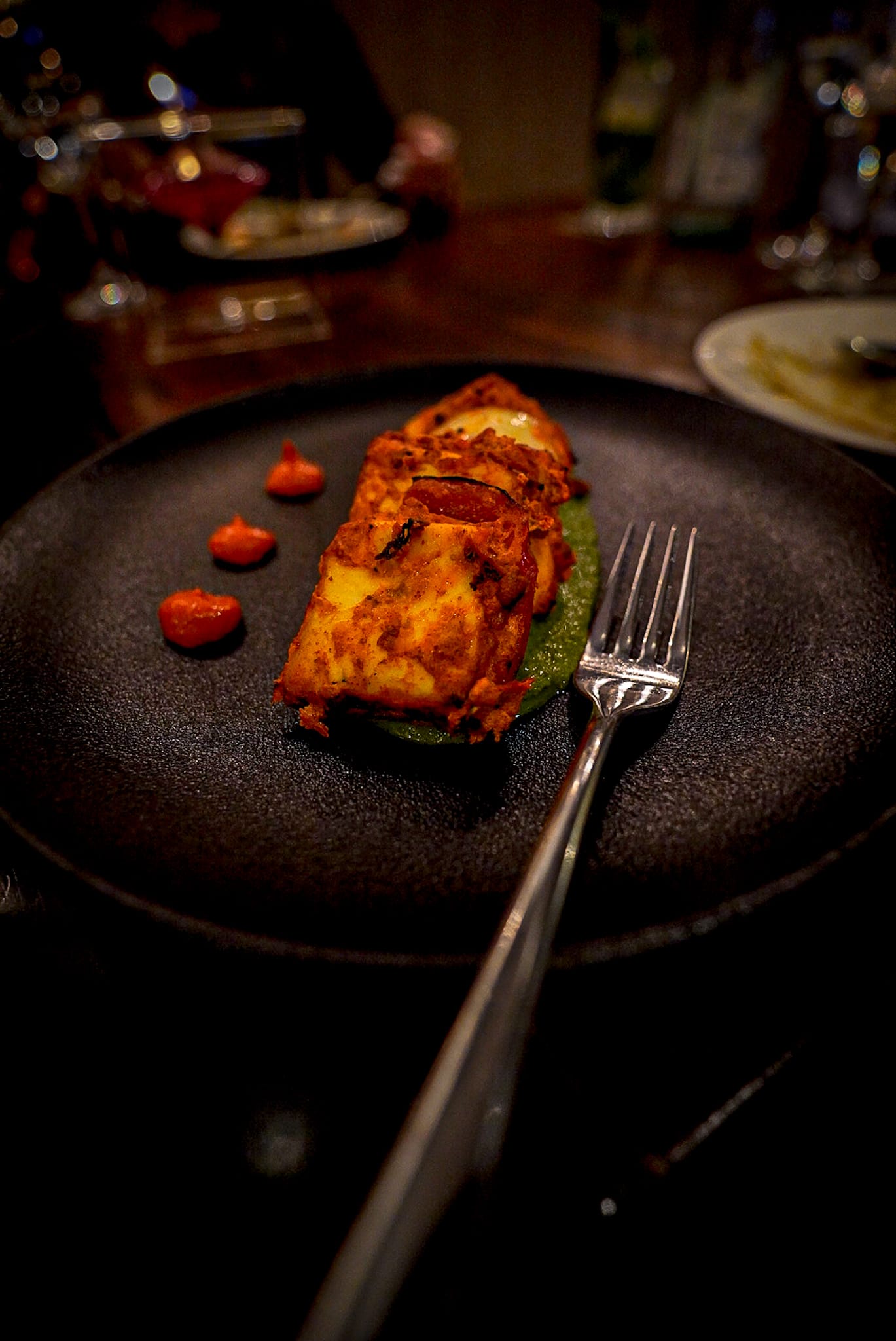 A close up of a plate of food with a fork on a table.