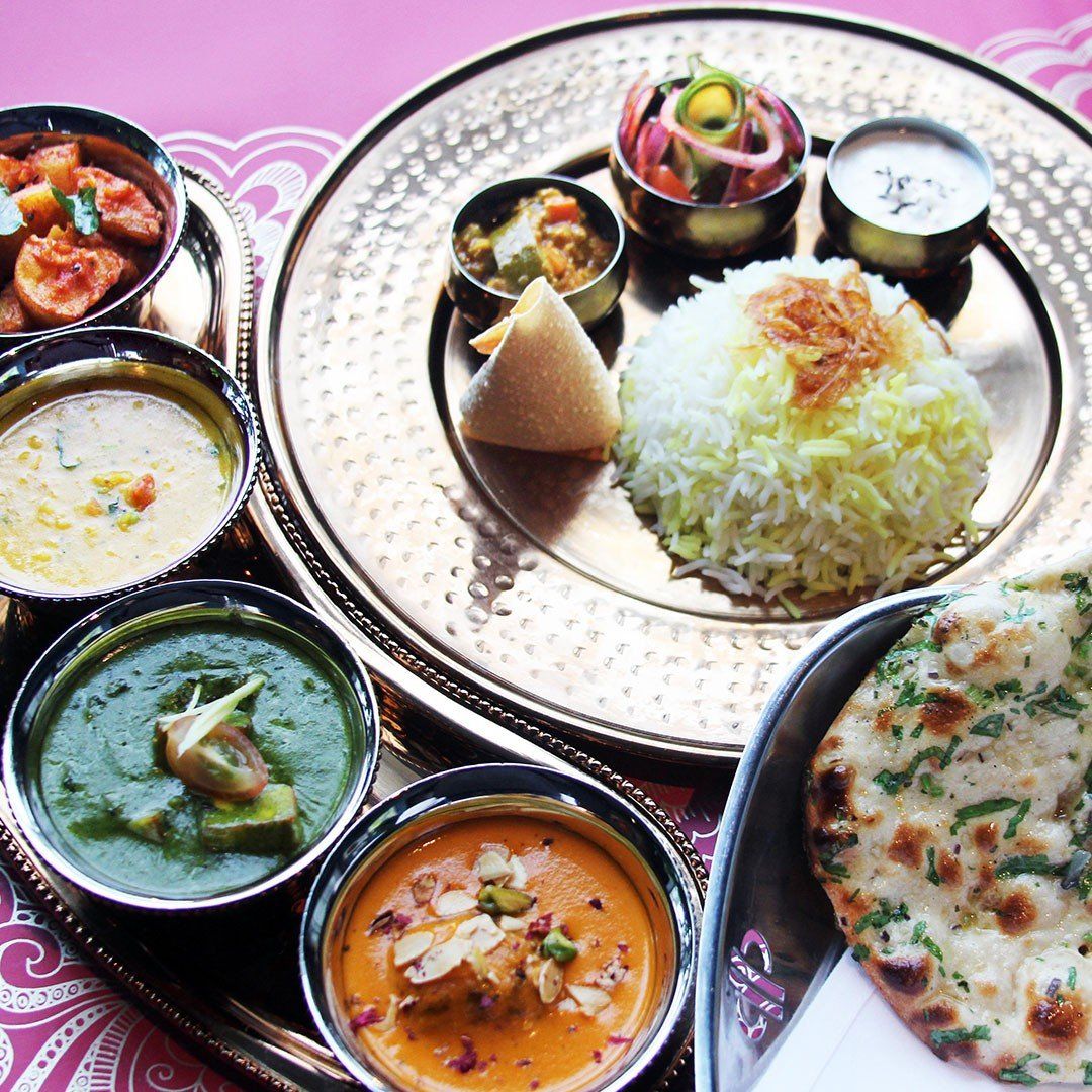 A plate of food with rice and soup on a table