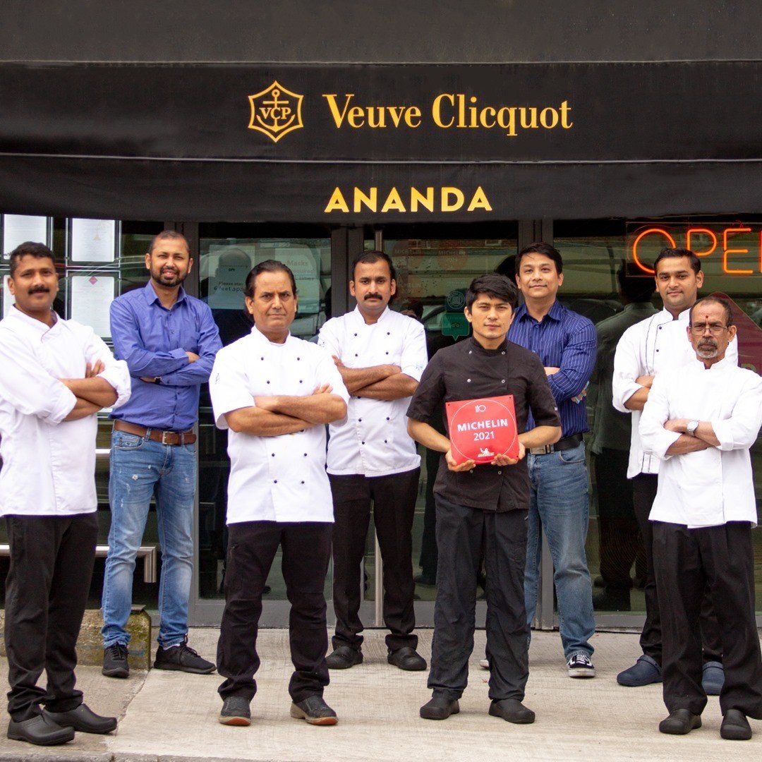 A group of men standing in front of veuve clicquot ananda