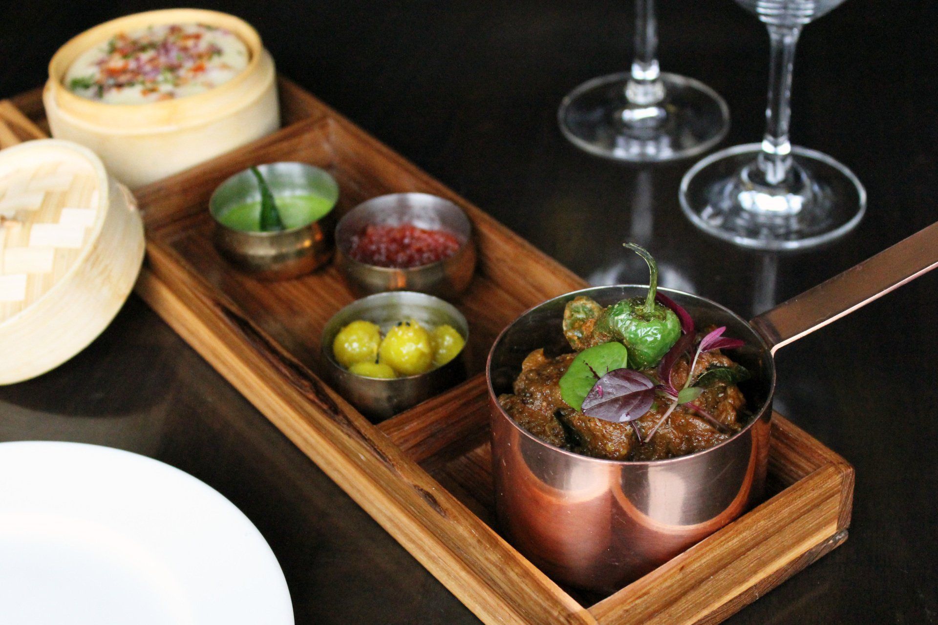 A wooden tray with a bowl of food on it