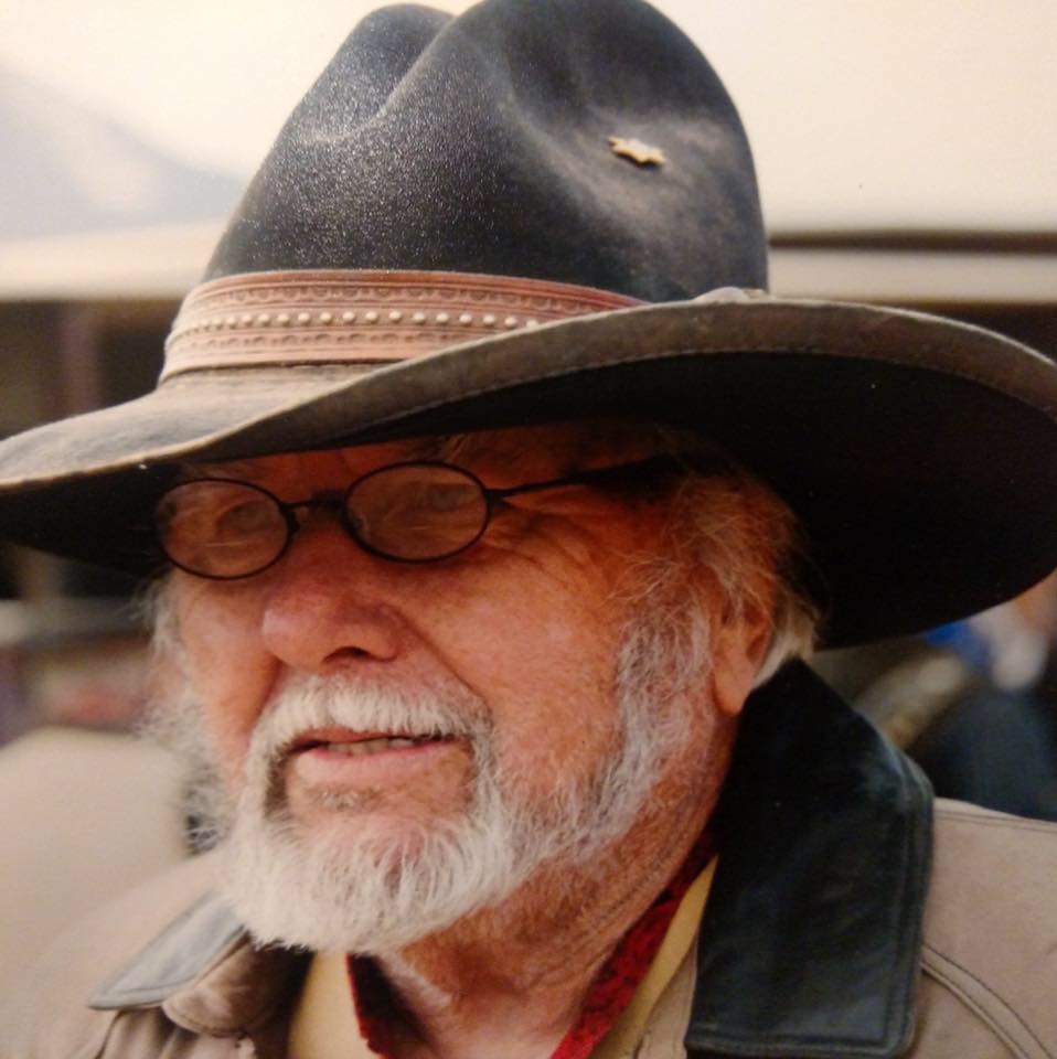 A man with a beard wearing a cowboy hat and glasses