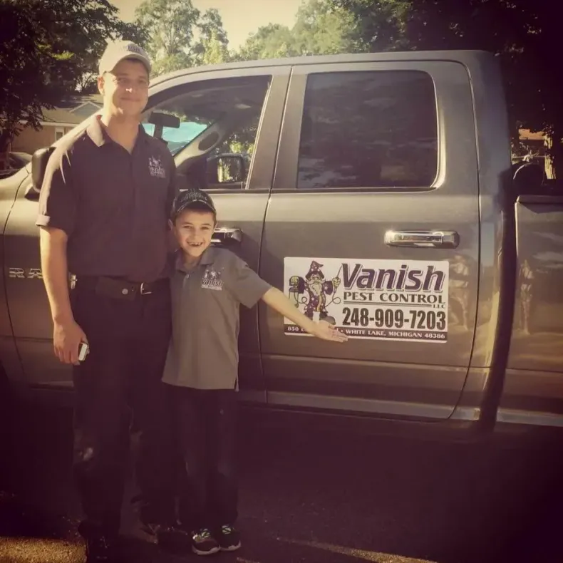 Man and boy standing by a truck with 
