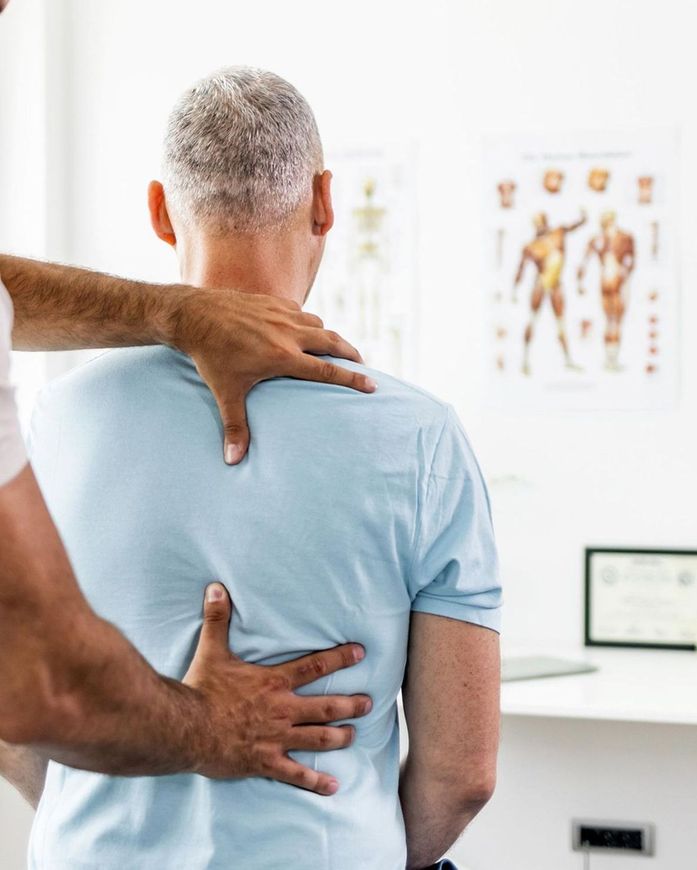 Chiropractor Checking Patient's Back — Etowah, NC — Huskey Chiropractic Center