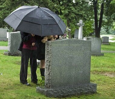 Family Mourning At The Cemetery — Quality Cremation Services in Rockhampton, QLD