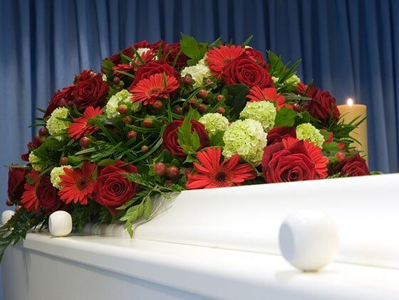 Red & White Flowers On The Coffin — Quality Cremation Services in Rockhampton, QLD
