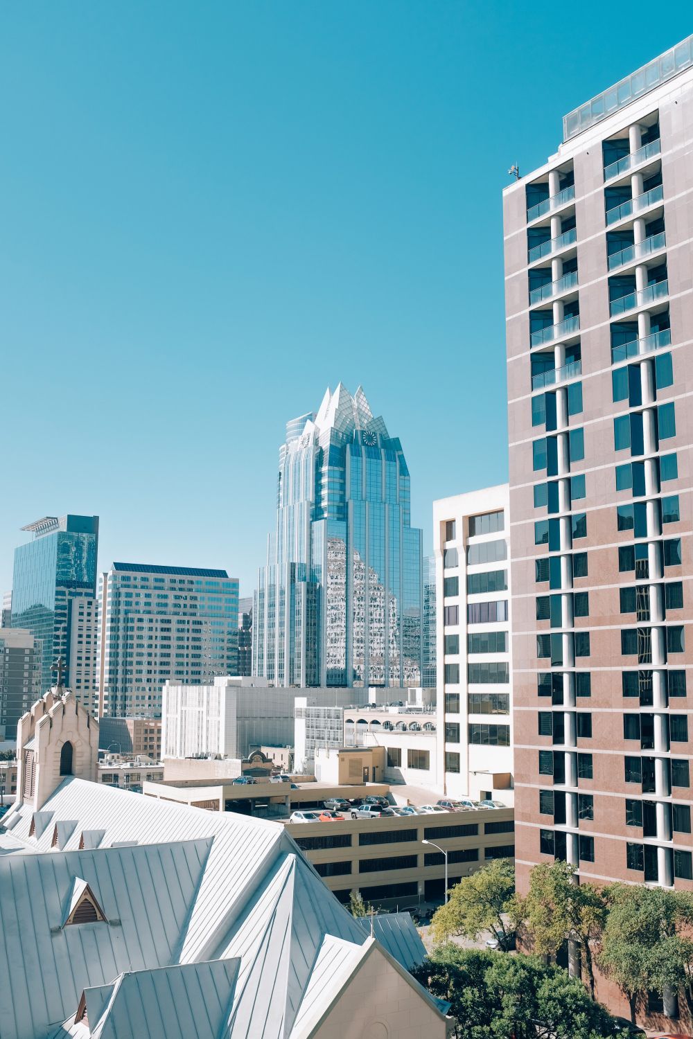 City skyline with modern skyscrapers against a clear blue sky.