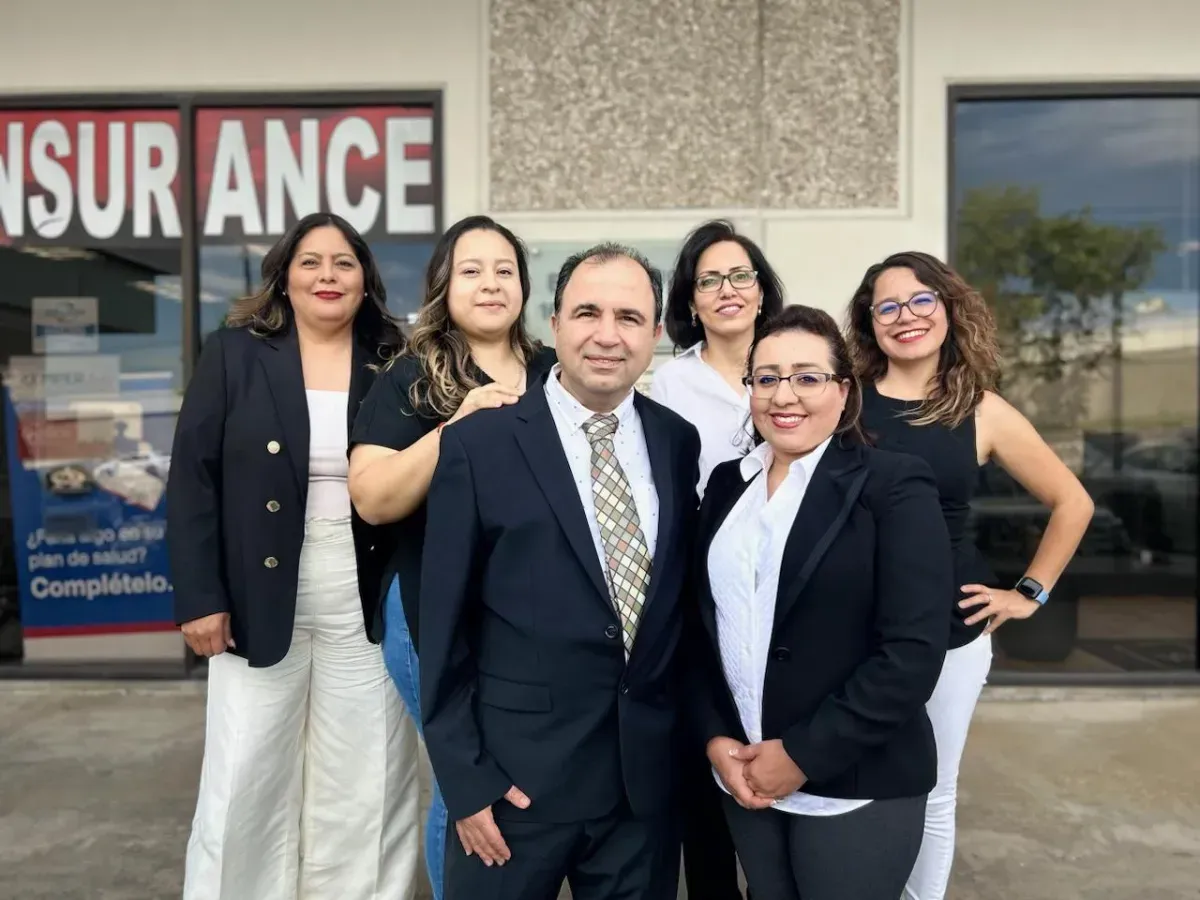 The team at All World Insurance / Austin Tax Masters posing outside their insurance office.