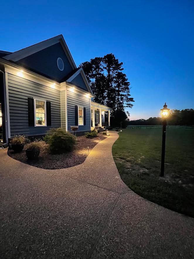 a house is lit up at night with a lamp post in front of it .