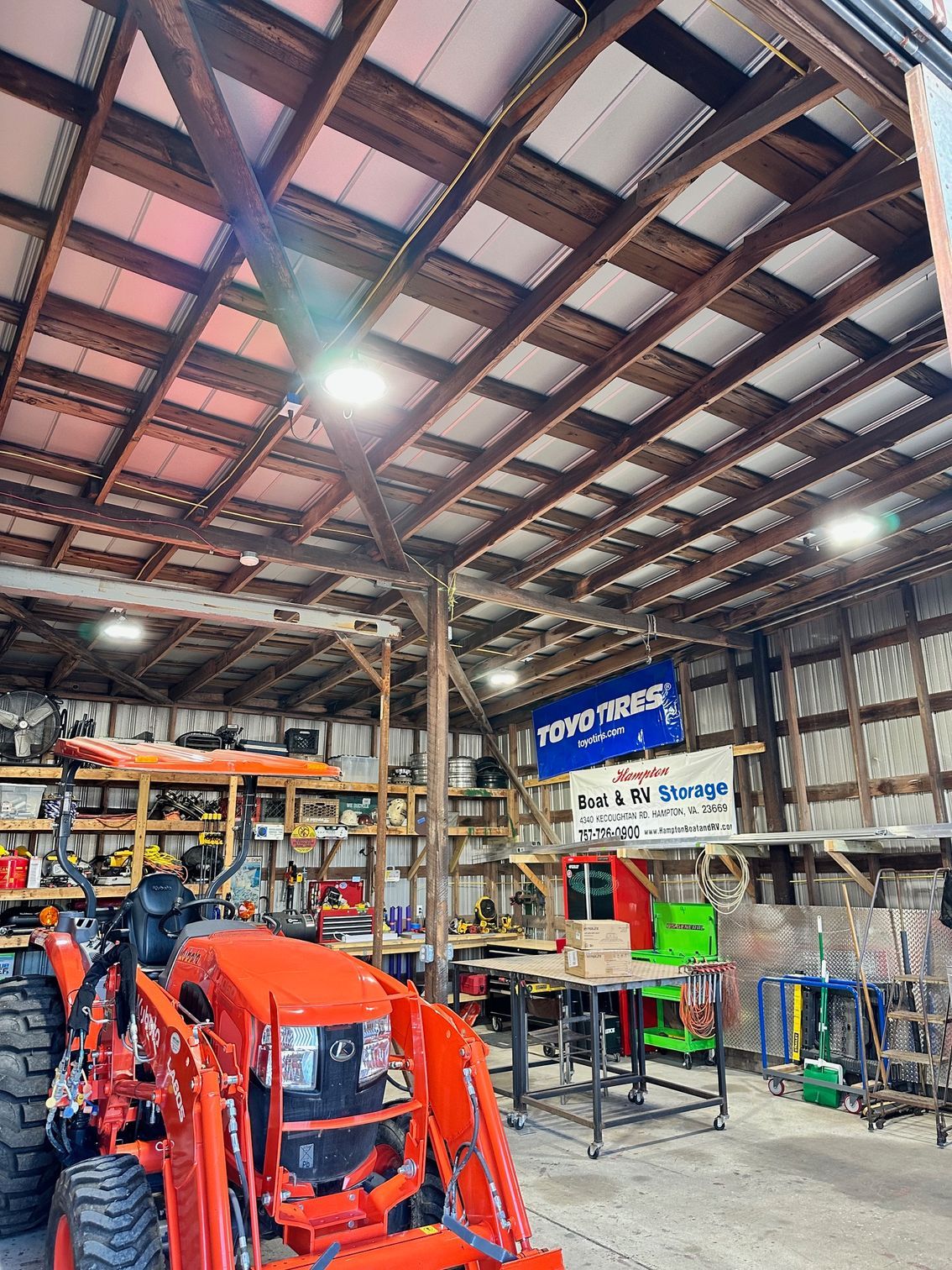 a tractor is parked inside of a barn .