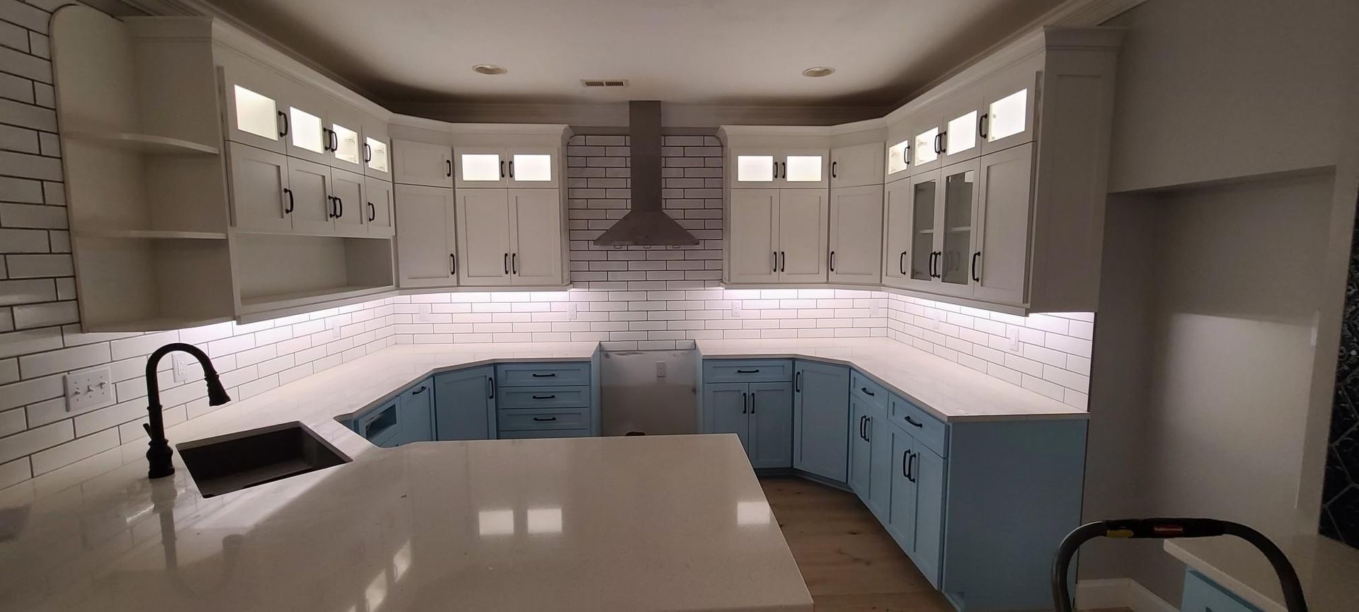 a kitchen with blue cabinets and white counter tops .