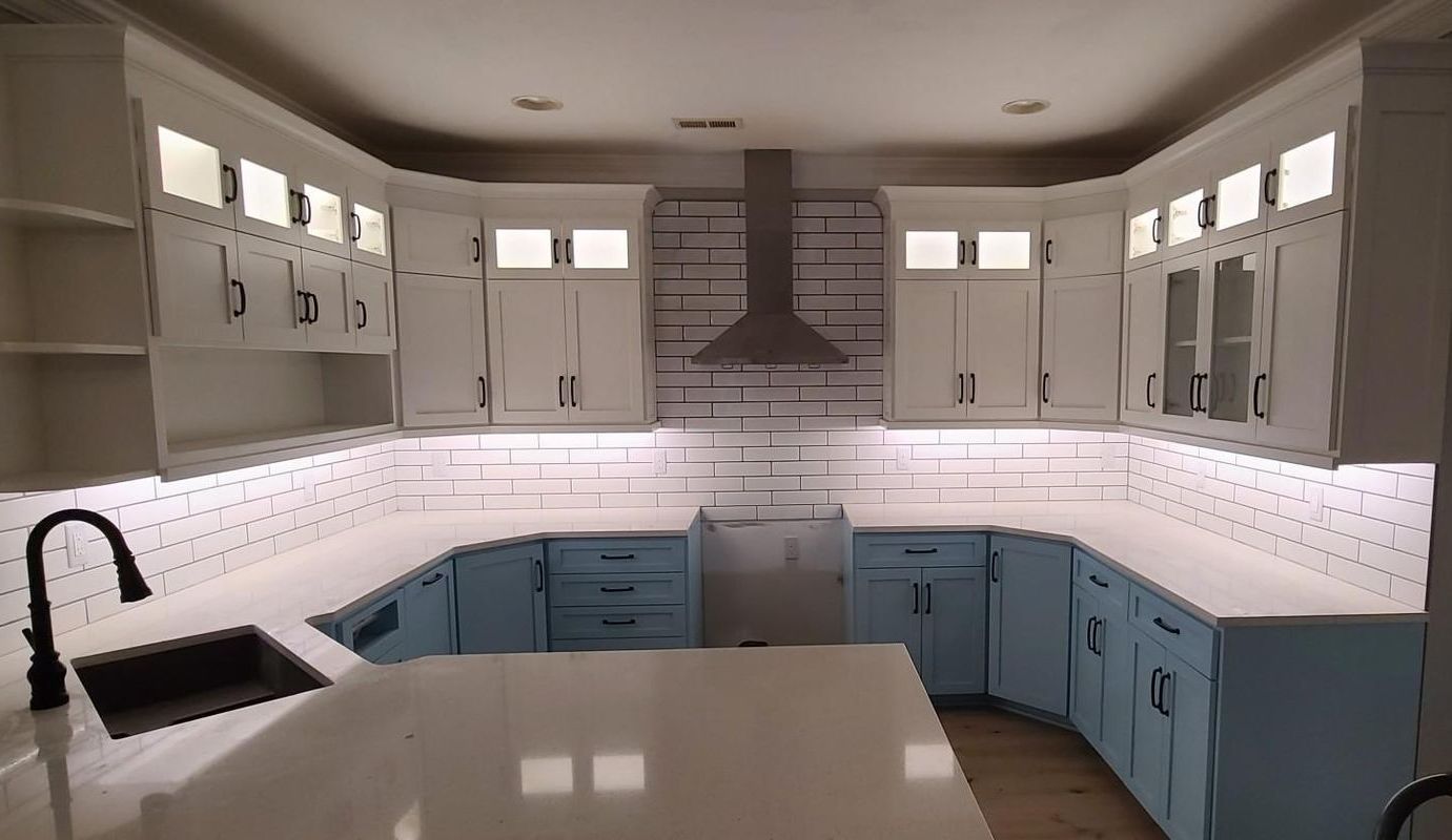 A kitchen with blue cabinets and white counter tops
