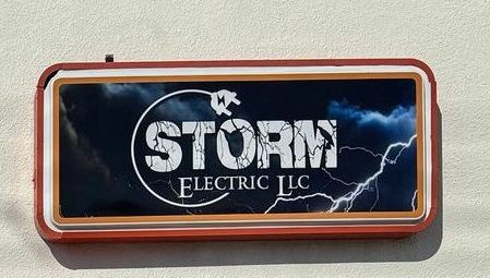 a sign for storm electric llc is on the side of a building .