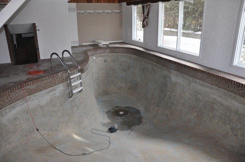 Une piscine vide avec un escalier qui y mène