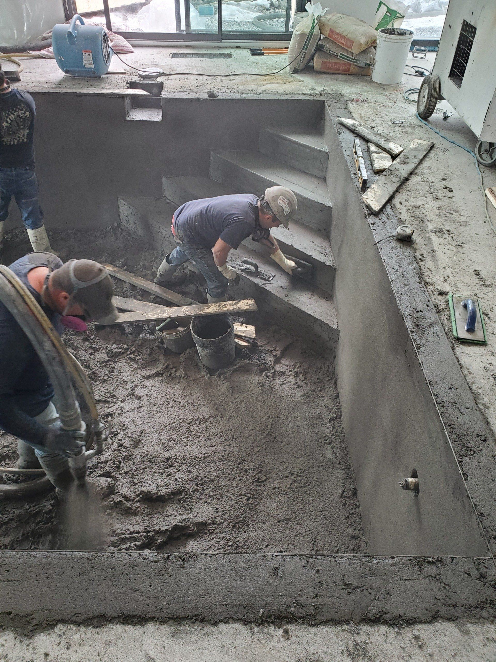 Un groupe d'hommes travaille sur une piscine.