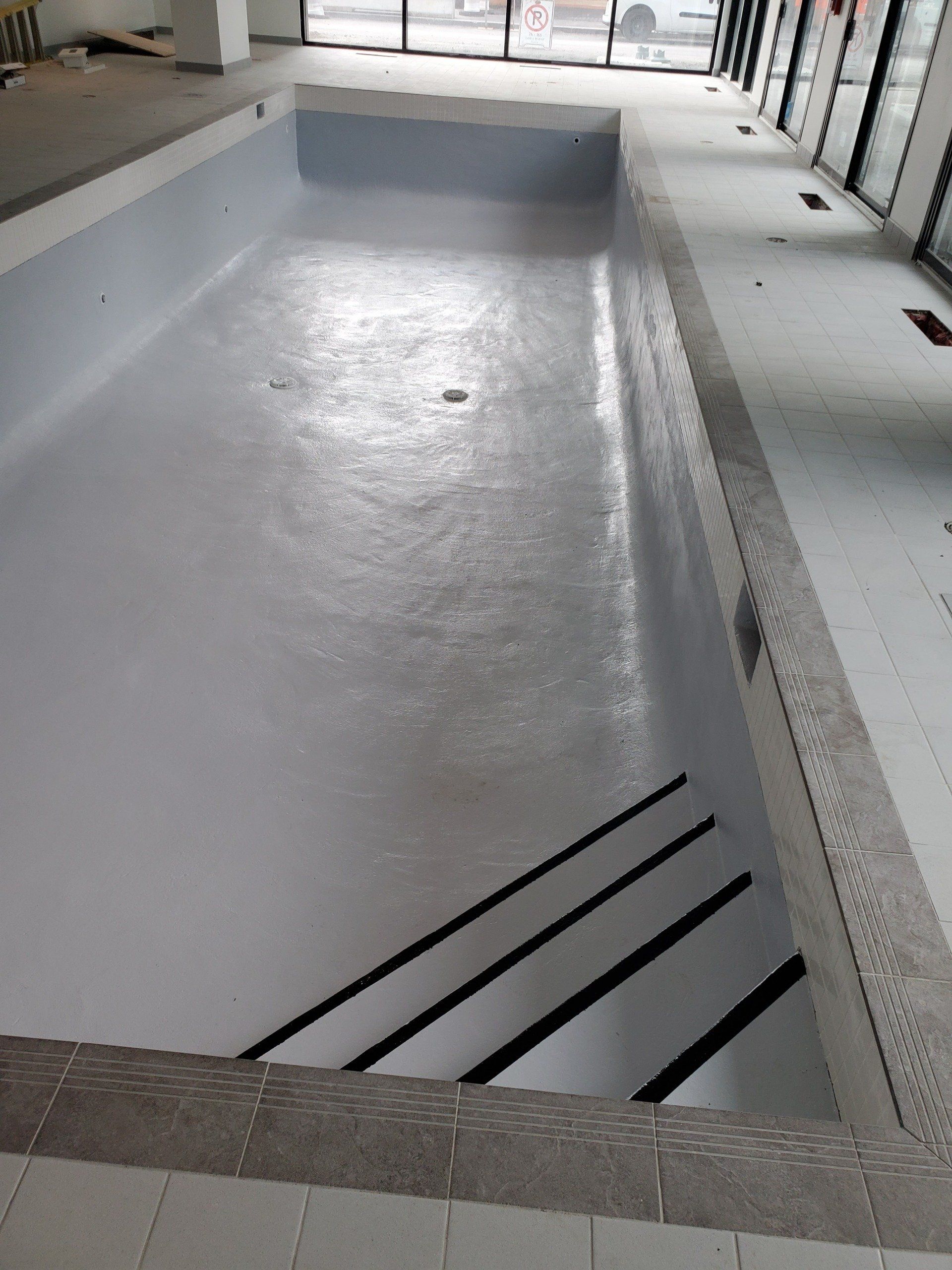 Une grande piscine intérieure avec des escaliers qui y mènent