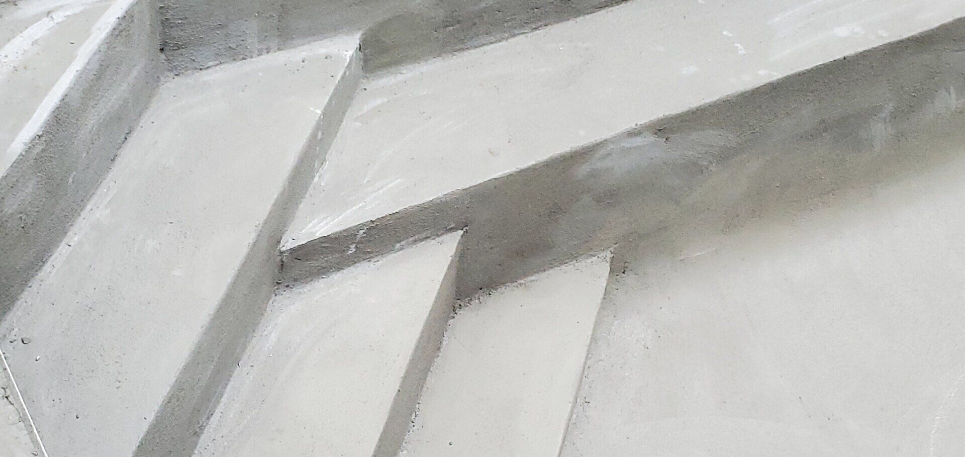 Marches en béton, grises et blanches, motif géométrique.