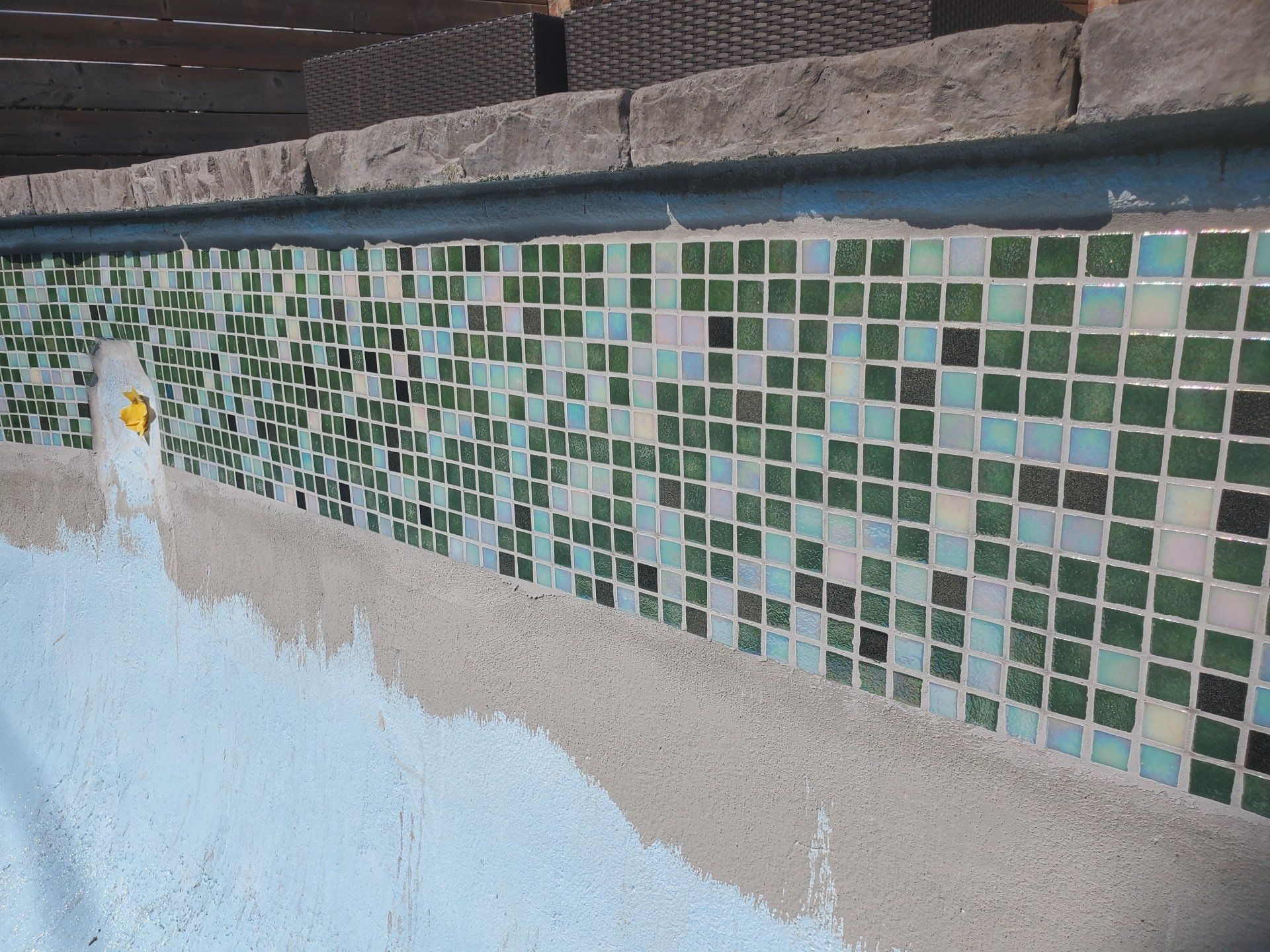 Une piscine avec des carreaux verts et blancs dessus