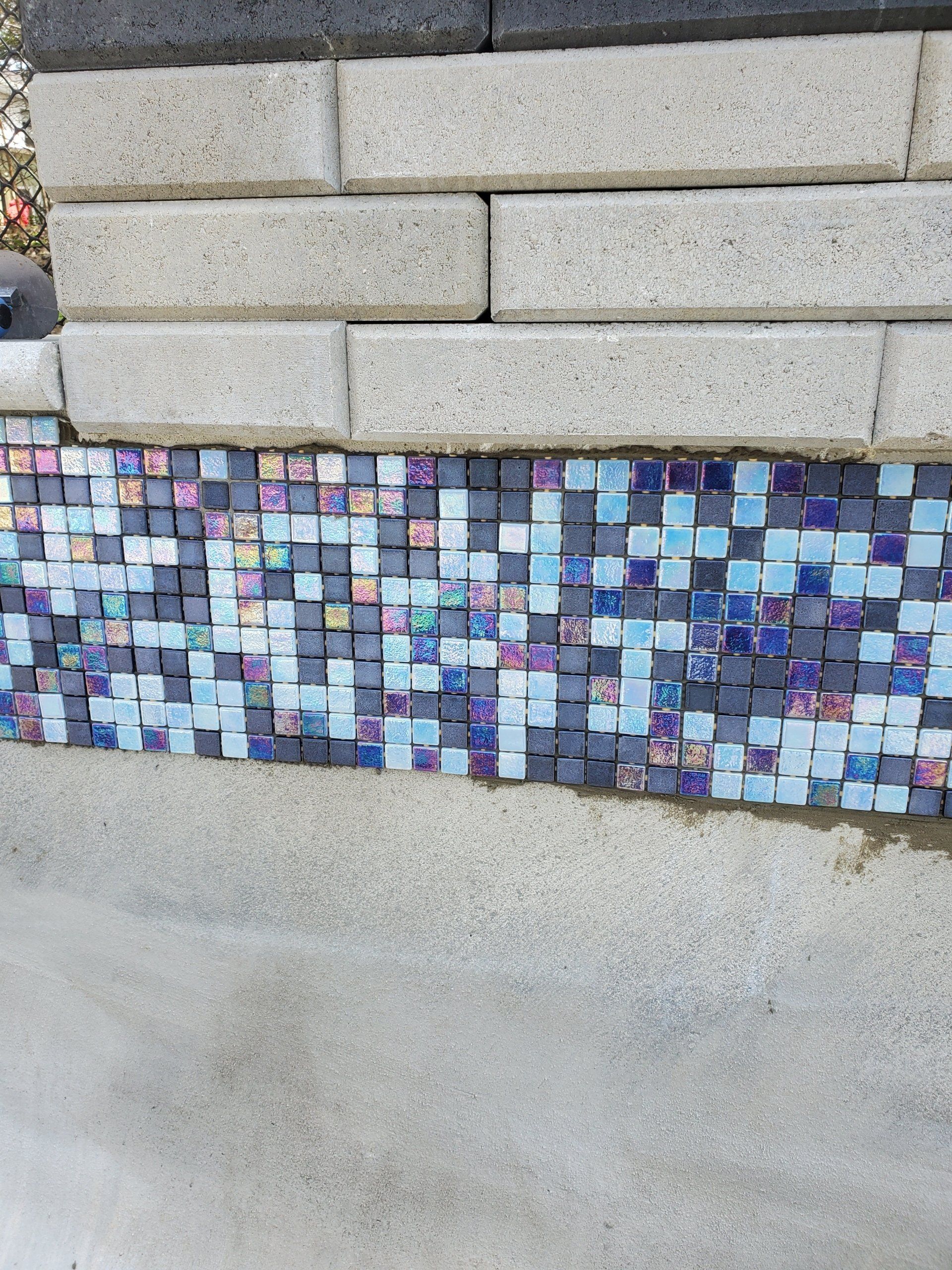 Un gros plan d'un mur de briques avec une mosaïque dessus.