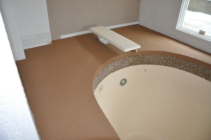 Une grande baignoire avec un banc au milieu dans une pièce.