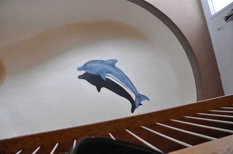 Un dauphin est peint sur le mur au-dessus d'un escalier