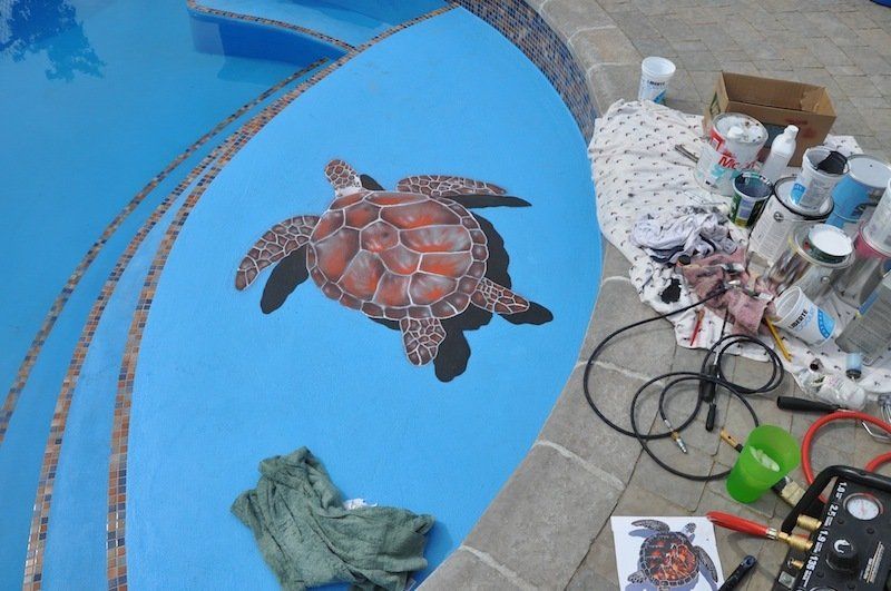 Une tortue est peinte sur le bord d'une piscine