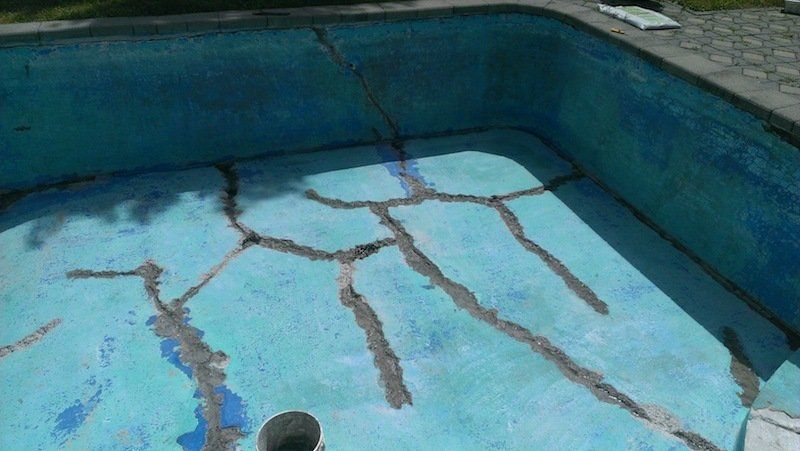 Une piscine avec des fissures au fond.