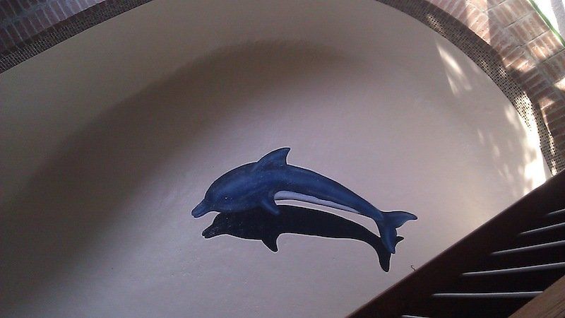 Deux dauphins bleus sont peints sur un mur blanc