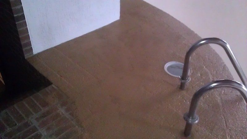 Un gros plan d'une piscine avec des escaliers qui y mènent.