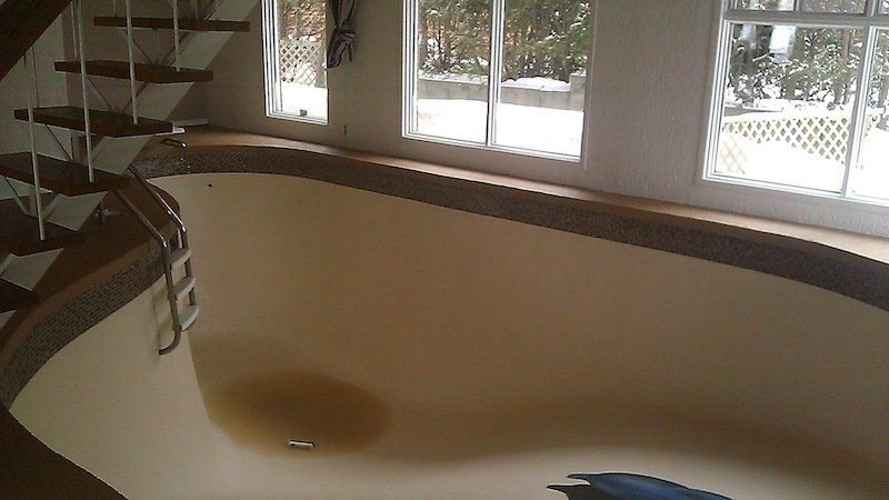 Une piscine vide avec des escaliers en arrière-plan