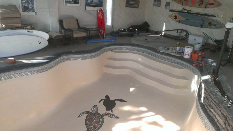 Une piscine avec deux tortues de mer peintes sur le sol.
