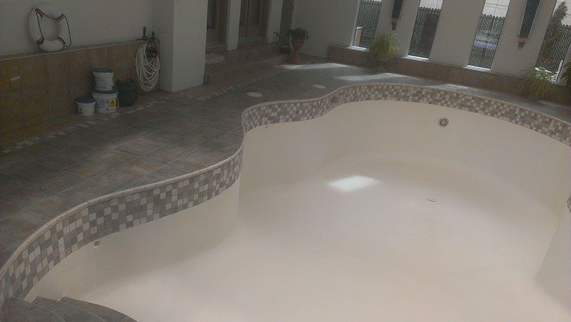 Une grande piscine est en cours de rénovation dans une maison.