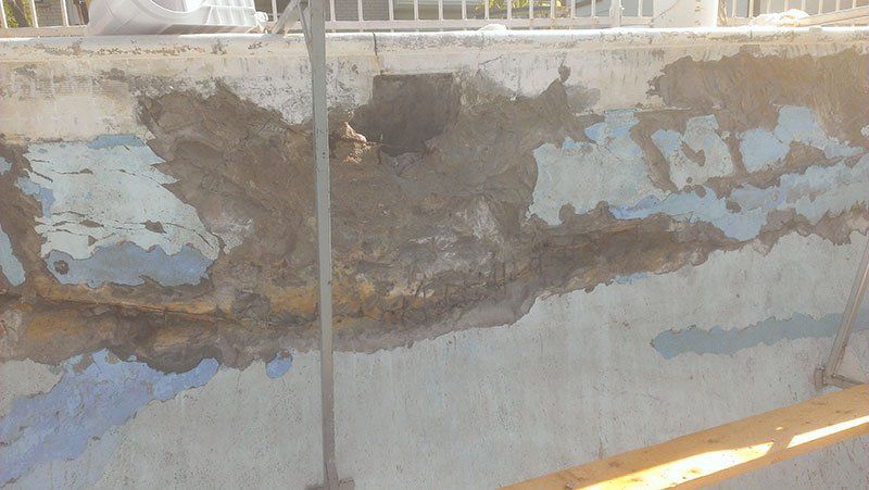 Un gros plan d'un mur en béton avec un trou dedans.