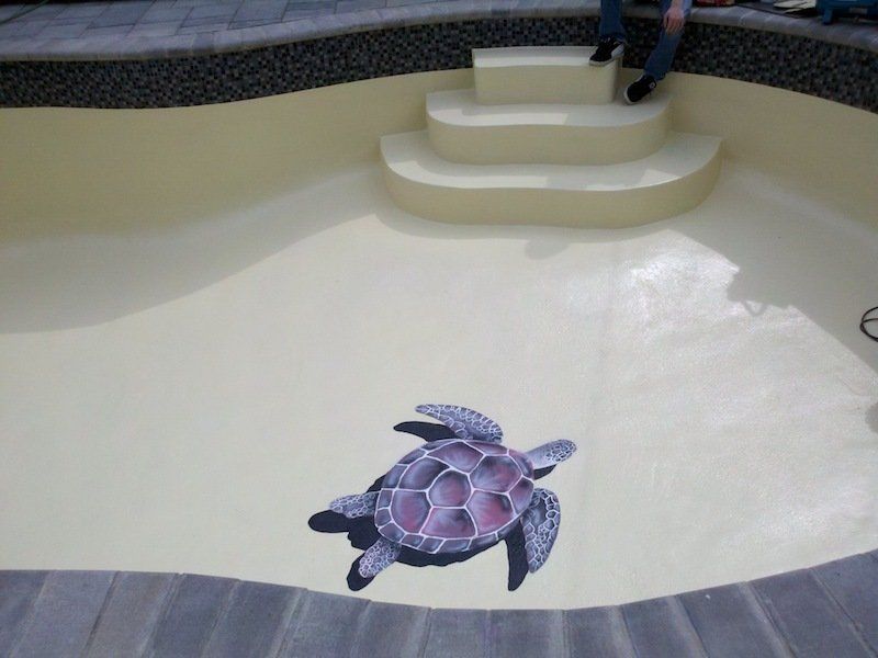 Une tortue est peinte sur le sol d'une piscine