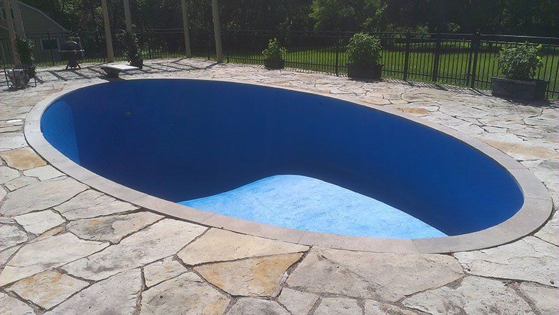 Une grande piscine de forme ovale avec de l'eau bleue