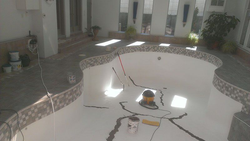 Une piscine est en train d'être peinte dans une maison.