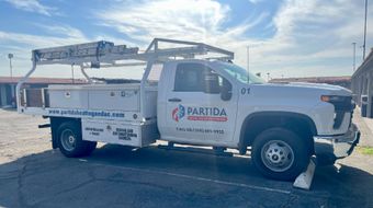 a white truck with the word partida on the side is parked in a parking lot .