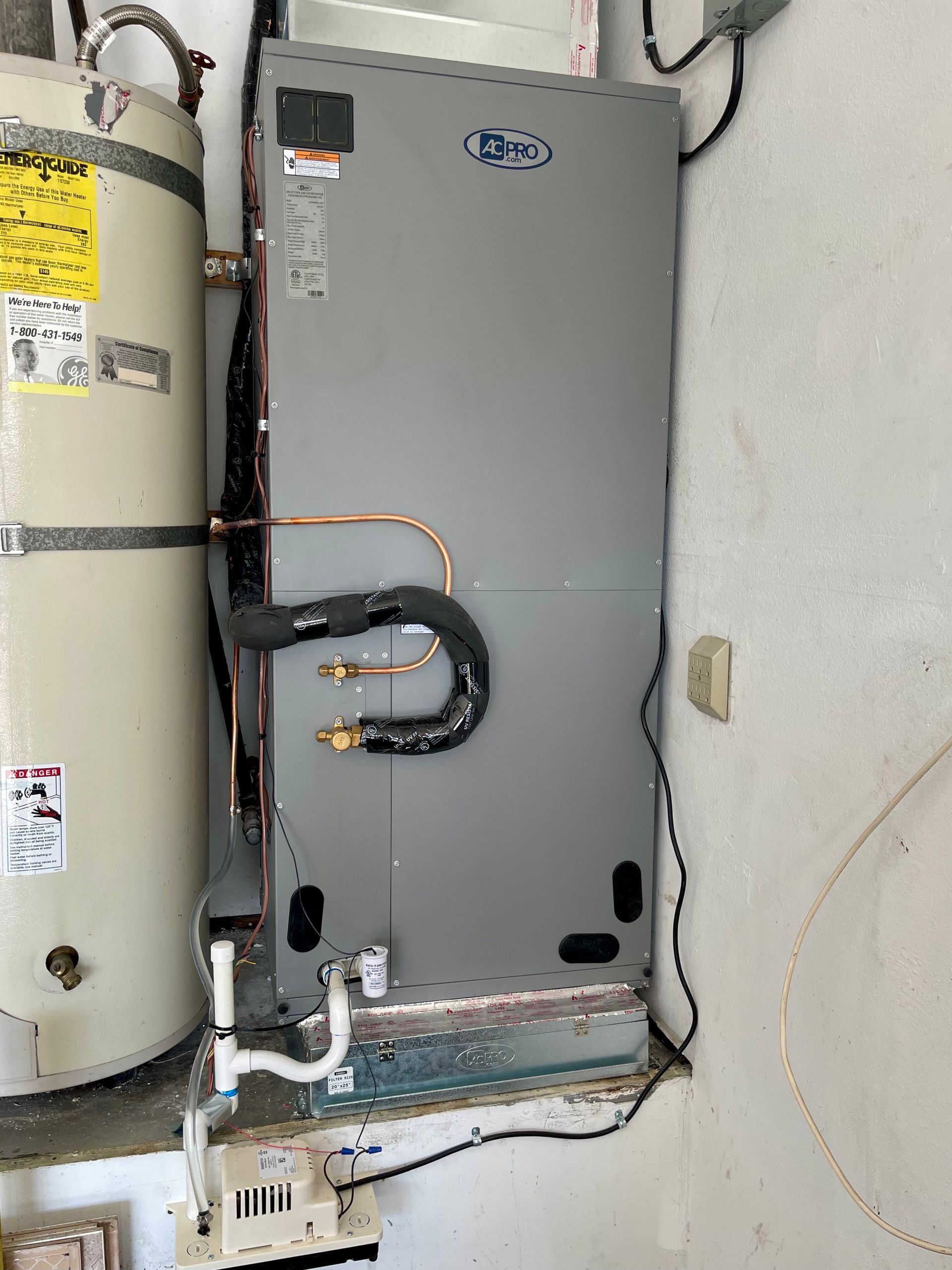 grey heat pump unit  installed next to water heater