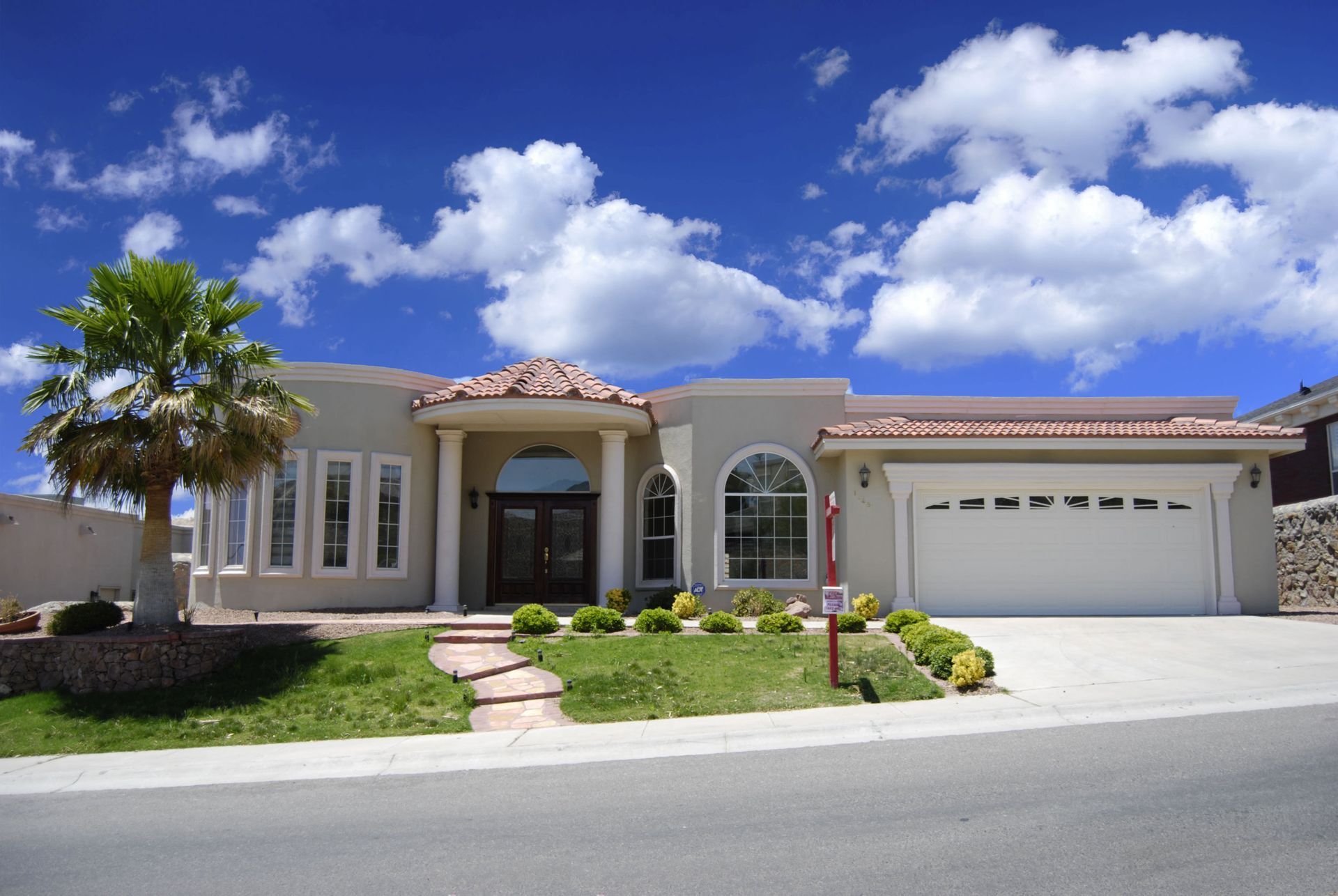 A large white house with a palm tree in front of it