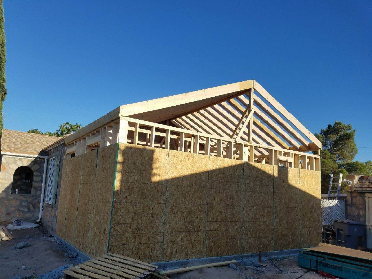 A wooden structure is being built on top of a house.