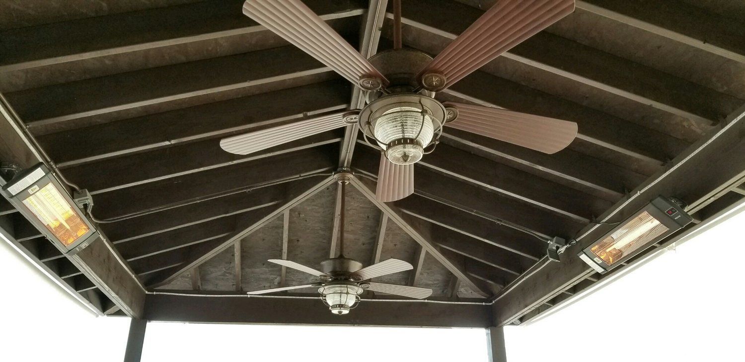 A ceiling fan is hanging from the ceiling of a gazebo.