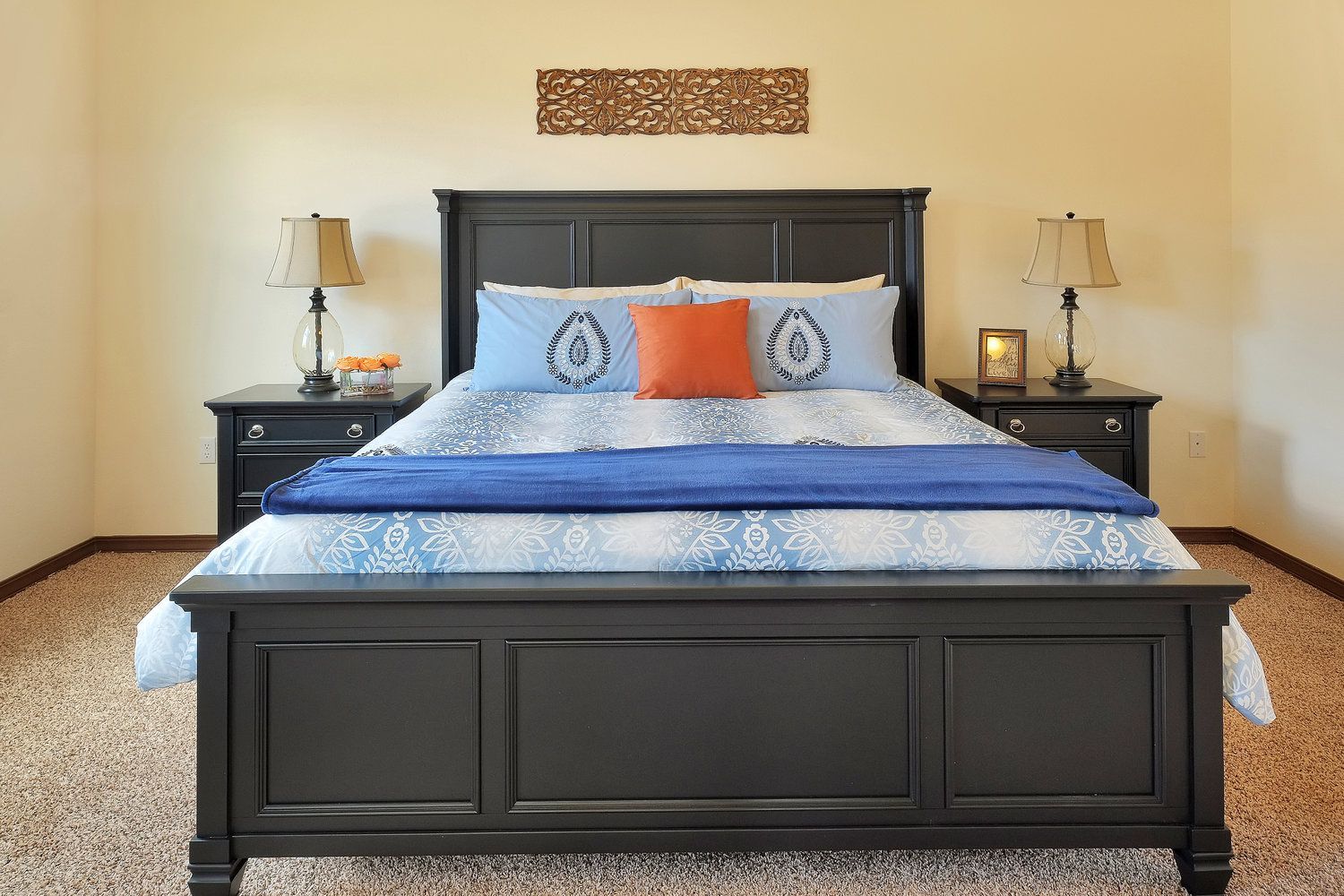 A bedroom with a bed , nightstands , and lamps.