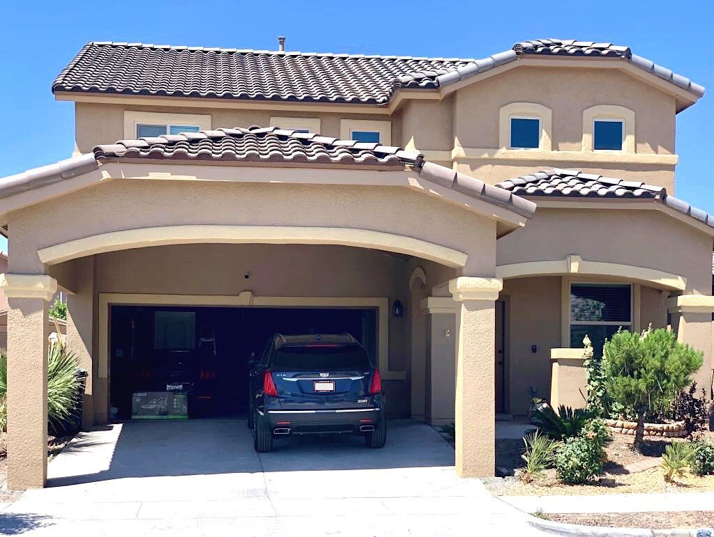 A car is parked in front of a large house