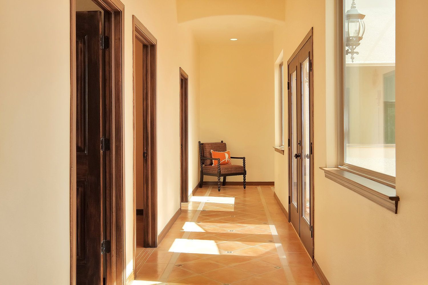 A long hallway with a chair and a window