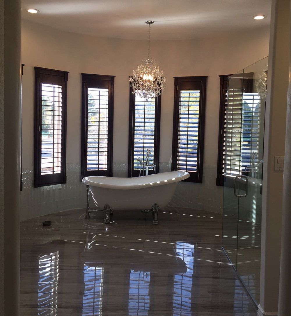 A bathroom with a tub and a chandelier hanging from the ceiling