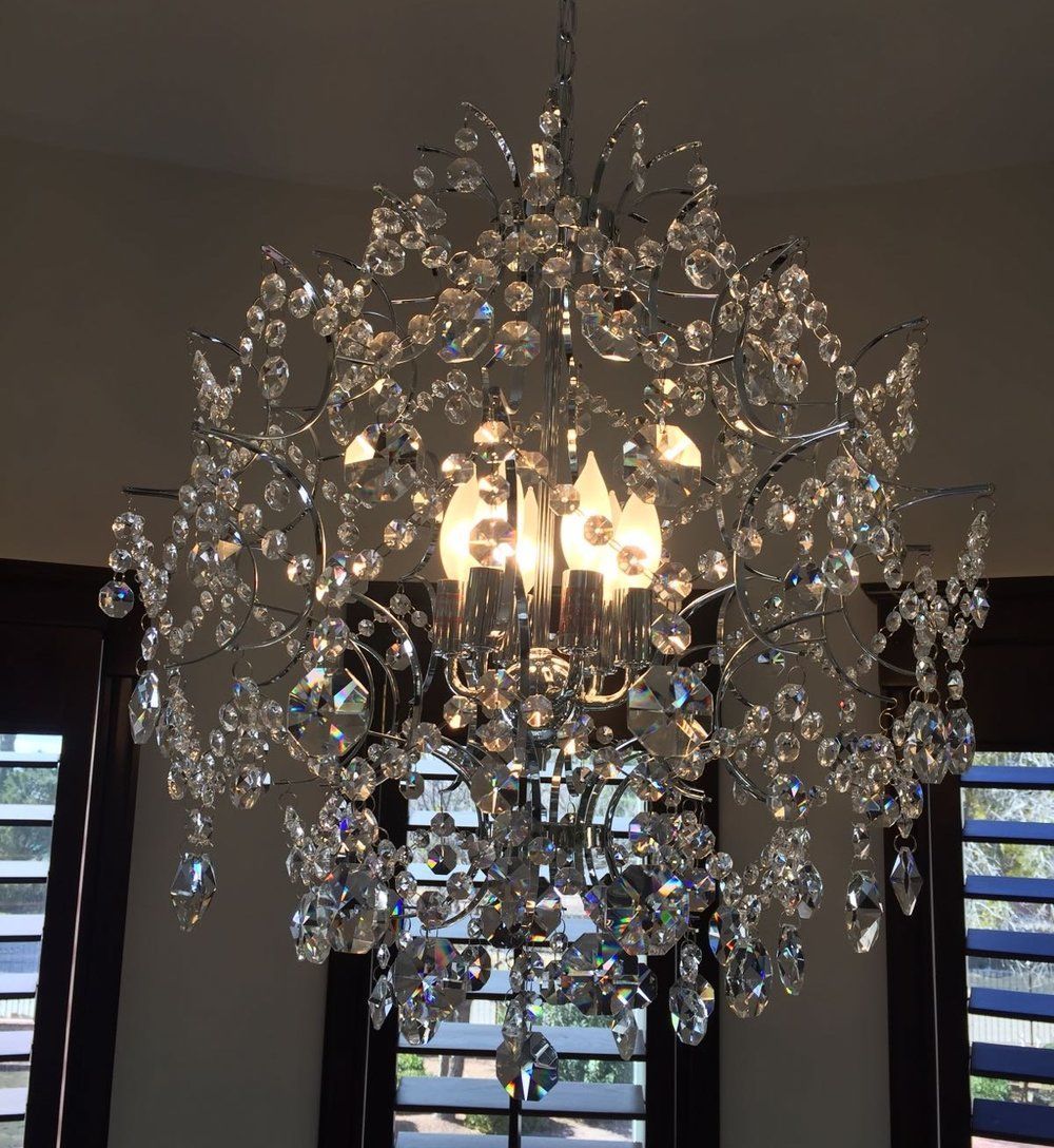 A chandelier is hanging from the ceiling in front of a window